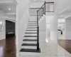 Stairs with crown molding, a fireplace, and wood-type flooring