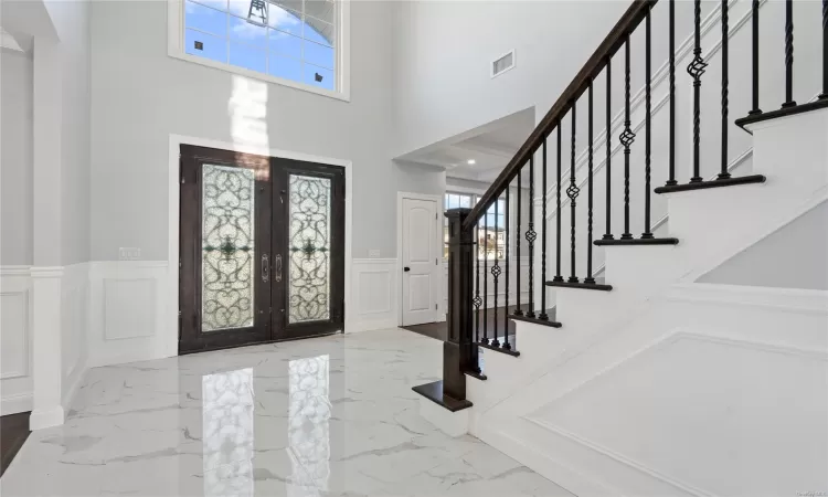 Foyer featuring french doors and a high ceiling