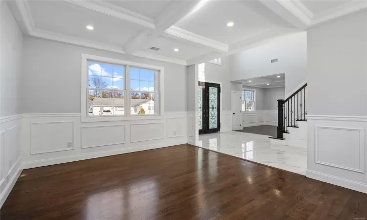 Entryway with beamed ceiling, hardwood / wood-style floors, and crown molding