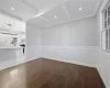 Unfurnished room with beam ceiling, dark hardwood / wood-style flooring, ornamental molding, and coffered ceiling