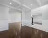 Empty room featuring beam ceiling, wood-type flooring, and crown molding