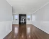 Unfurnished living room featuring dark hardwood / wood-style floors and ornamental molding