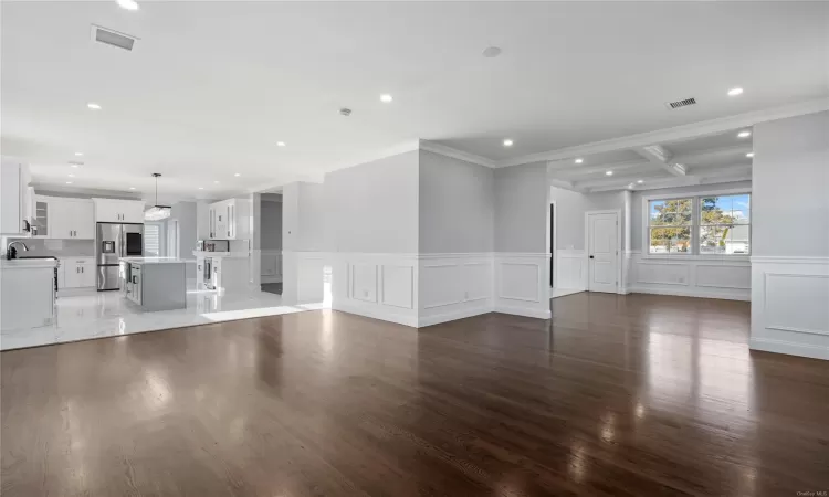 Unfurnished living room with dark hardwood / wood-style flooring, ornamental molding, and sink