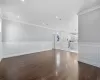 Unfurnished living room featuring dark hardwood / wood-style flooring and ornamental molding