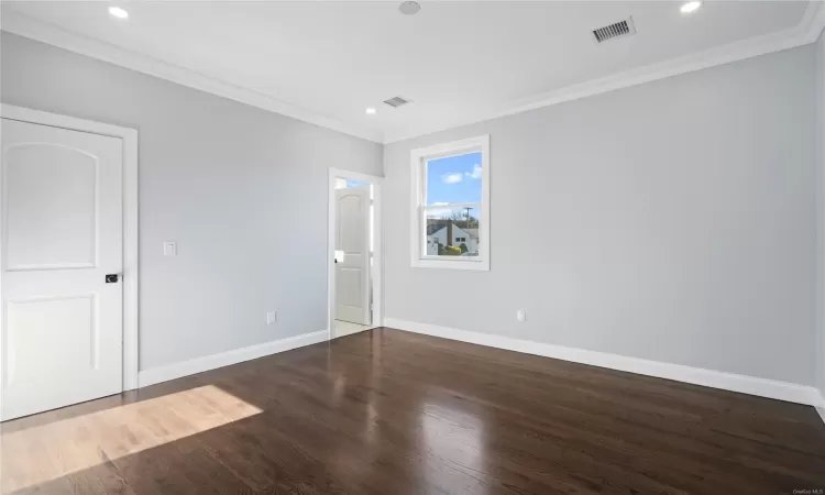 Unfurnished room with dark hardwood / wood-style flooring and ornamental molding