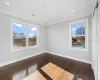 Empty room featuring plenty of natural light, dark hardwood / wood-style flooring, and ornamental molding