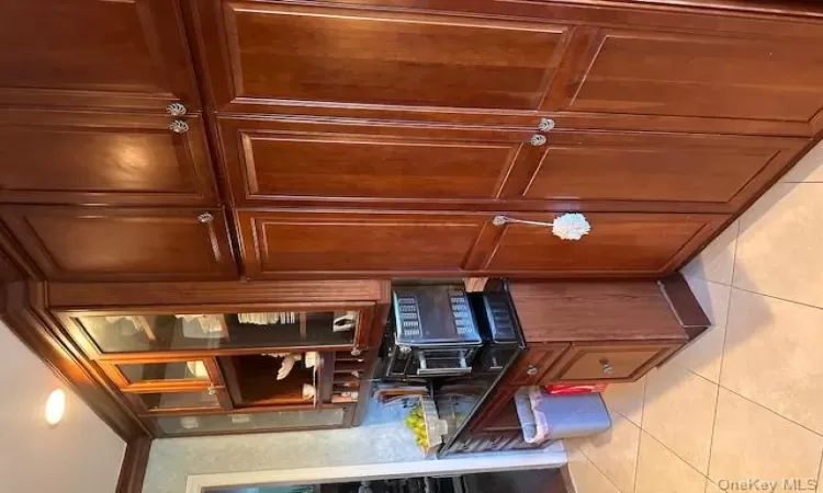 Kitchen featuring light tile patterned floors, ornamental molding, and dark stone counters