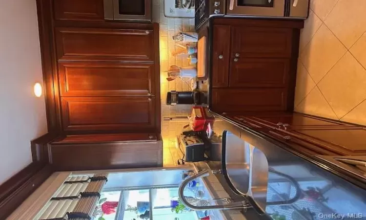 Kitchen featuring range, sink, light tile patterned floors, and tasteful backsplash