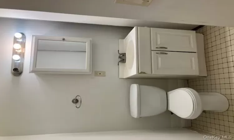 Bathroom featuring tile patterned floors, vanity, and toilet