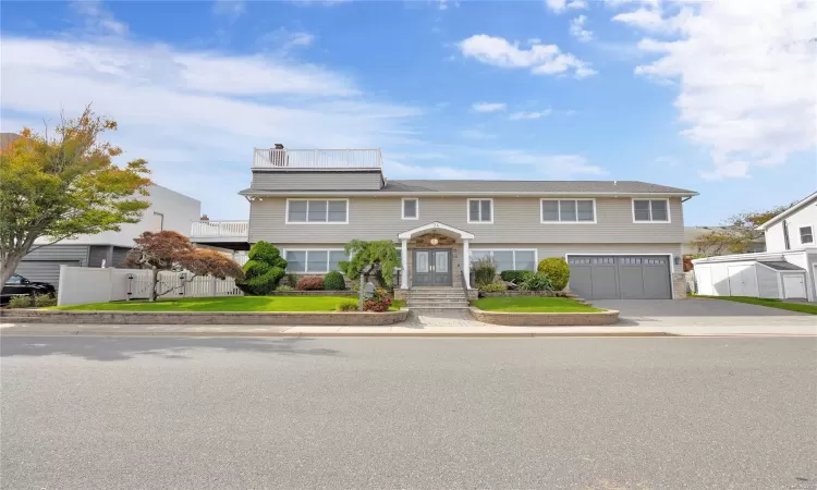 View of front of property featuring a front yard and a garage