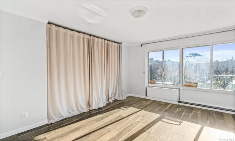 Unfurnished room featuring hardwood / wood-style floors and ornamental molding