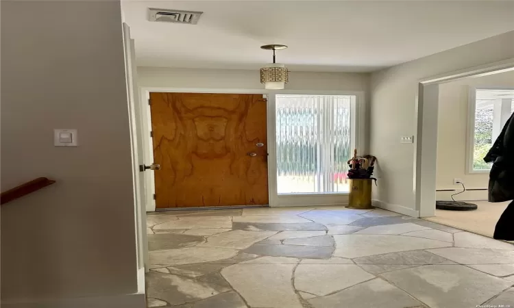 Basement with baseboard heating and light hardwood / wood-style flooring