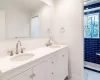 Bathroom featuring tiled shower, vanity, and ornamental molding