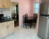 Kitchen with decorative backsplash, stainless steel fridge, light tile patterned floors, and light brown cabinetry