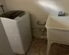 Laundry area with washer / dryer, light tile patterned floors, and sink