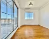 Empty room with an AC wall unit, light hardwood / wood-style floors, and baseboard heating