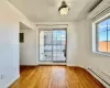 Spare room featuring baseboard heating, electric panel, light wood-type flooring, and an AC wall unit