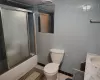 Full bathroom with vanity, shower / bath combination with glass door, tile walls, tile patterned flooring, and toilet