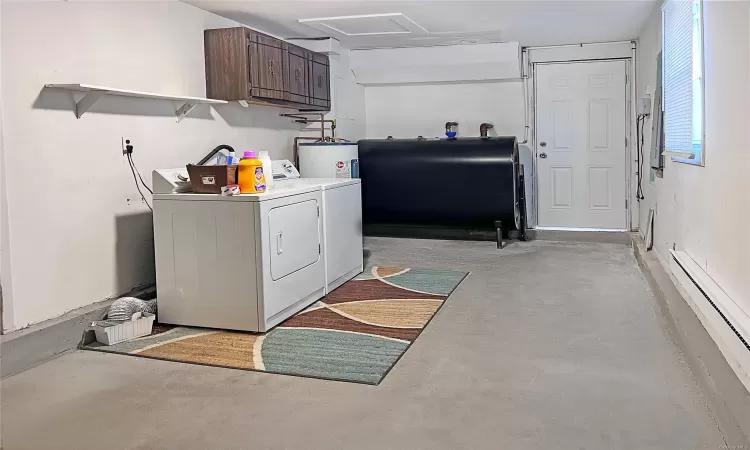 Garage featuring independent washer and dryer, electric water heater, and a baseboard radiator