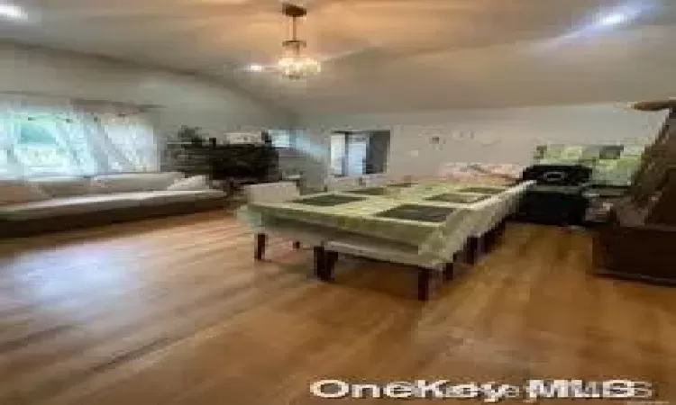 Dining room featuring wood-type flooring and vaulted ceiling