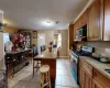 Kitchen with light stone countertops, a breakfast bar, stainless steel appliances, light tile patterned floors, and a center island