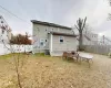 Rear view of property featuring central air condition unit and a lawn