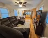 Kitchen with light brown cabinetry, ceiling fan with notable chandelier, stainless steel appliances, pendant lighting, and light hardwood / wood-style floors