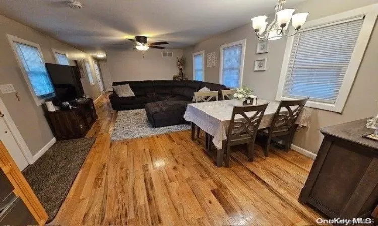 Dining area featuring ceiling fan with notable chandelier, light hardwood / wood-style floors, and plenty of natural light