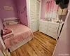 Bedroom featuring light wood-type flooring, ceiling fan, and multiple closets