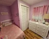 Bedroom featuring hardwood / wood-style floors, ceiling fan, and multiple closets