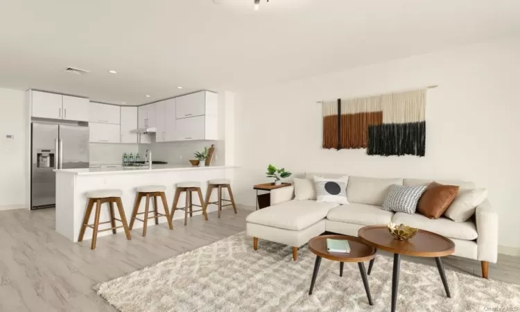 Living room with light hardwood / wood-style floors and sink