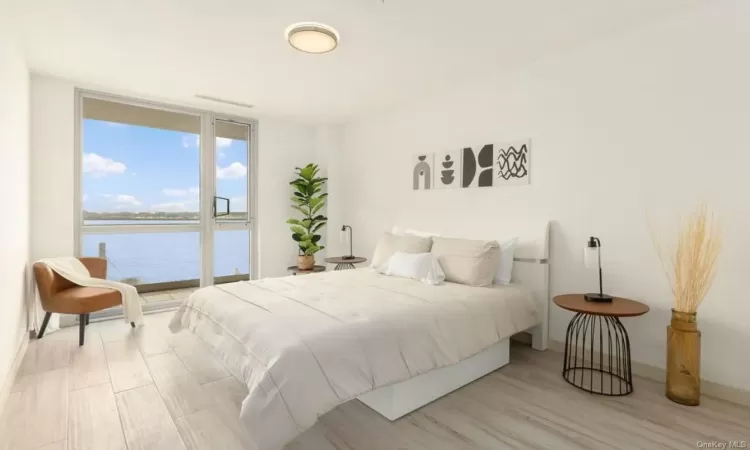 Bedroom with a water view and light wood-type flooring