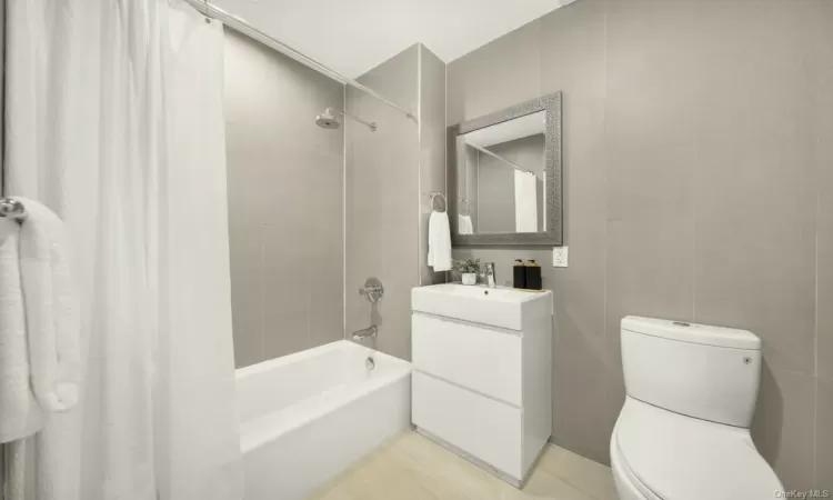 Full bathroom featuring vanity, toilet, and shower / bath combo with shower curtain