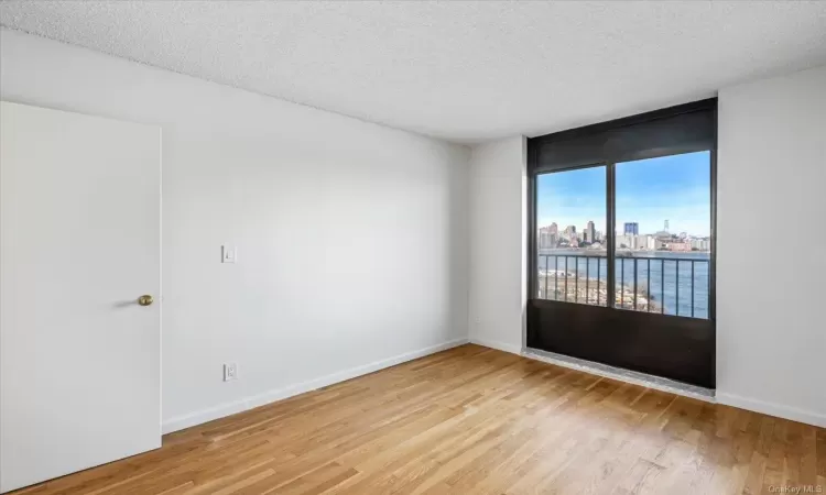 Empty room featuring light hardwood / wood-style flooring and a textured ceiling