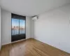 Unfurnished room featuring a wall mounted air conditioner, a textured ceiling, and light hardwood / wood-style flooring