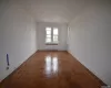 Unfurnished room featuring radiator heating unit and dark parquet floors