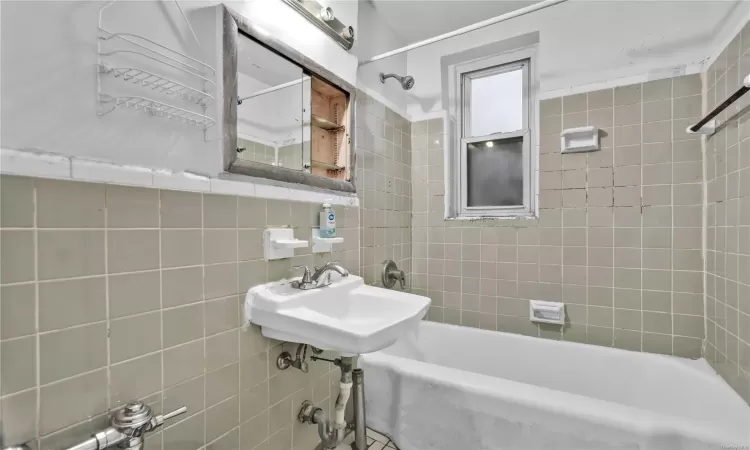 Kitchen featuring hardwood / wood-style floors, gas stove, sink, cream cabinets, and tasteful backsplash