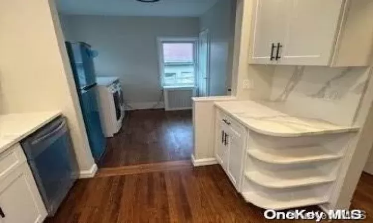 Spare room with radiator and dark hardwood / wood-style flooring