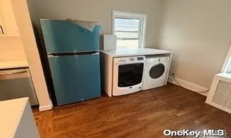 Spare room with a wealth of natural light, radiator heating unit, and dark hardwood / wood-style floors