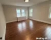 Unfurnished room with dark hardwood / wood-style flooring and radiator