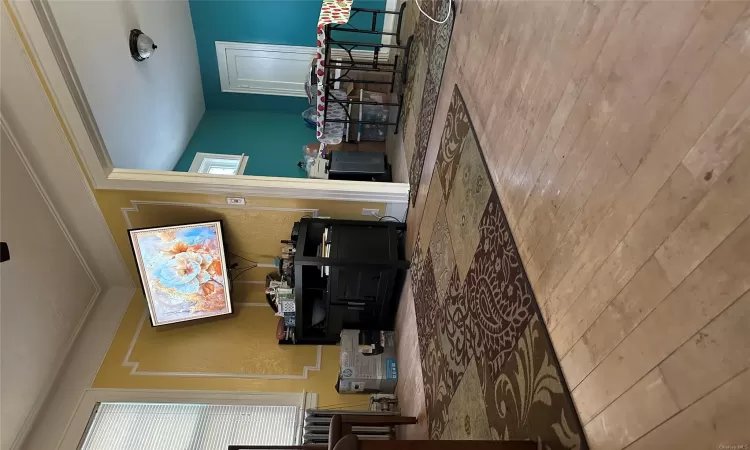 Living room with crown molding, radiator heating unit, and wood-type flooring