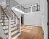 Staircase featuring a healthy amount of sunlight, a high ceiling, and hardwood / wood-style flooring