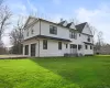 Rear view of house with a garage and a lawn