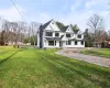 View of front facade featuring central AC unit, a front yard, and a pool