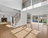 Unfurnished living room featuring a towering ceiling and light hardwood / wood-style floors