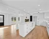 Kitchen featuring light stone countertops, a center island, light hardwood / wood-style floors, and white cabinetry