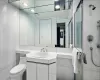 Bathroom with vanity, a shower with door, toilet, and tile walls