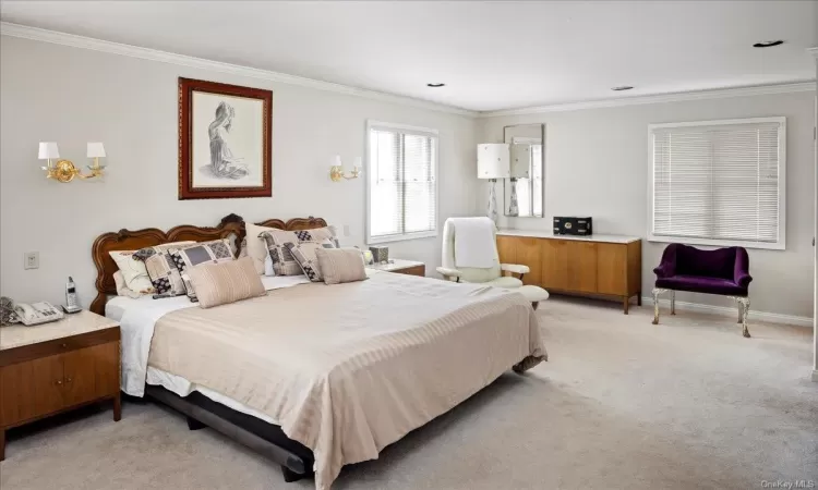 Carpeted bedroom with ornamental molding