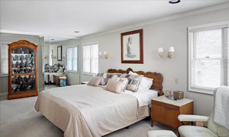 Bedroom featuring light carpet and ornamental molding