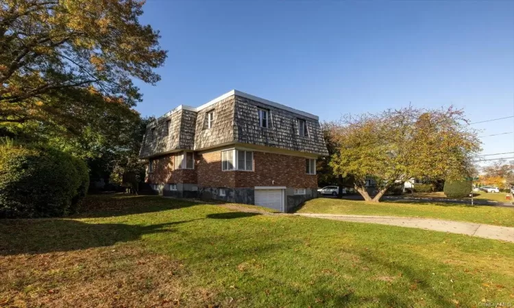 View of side of home with a yard